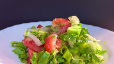 Macro shot of a salad with fresh vegetables and herbs. Freshly made Mediterranean salad on plate.