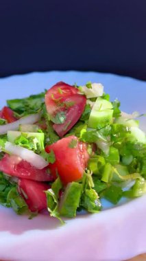 Macro shot of a salad with fresh vegetables and herbs. Freshly made Mediterranean salad on plate.