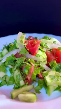 Macro shot of a salad with fresh vegetables and herbs. Freshly made Mediterranean salad on plate.