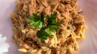 Orzo pasta dish with ground meat and tomato sauce. Plate of orzo pasta with meat sauce.