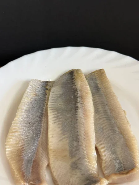 Hafif tuzlu ringa fileto balığının beyaz tabakta yakın çekimi. Sağlıklı, doğal yiyecekler..