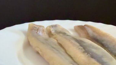 Hafif tuzlu ringa fileto balığının beyaz tabakta yakın çekimi. Sağlıklı, doğal yiyecekler..