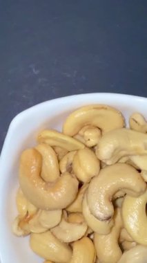 Beyaz bir kasede kurutulmuş kaju fıstığı yakın plan. Sağlıklı, doğal yiyecekler..