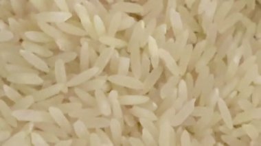 Beyaz bir kasede beyaz uzun tahıllı pirinç. Pişmemiş pirinç..