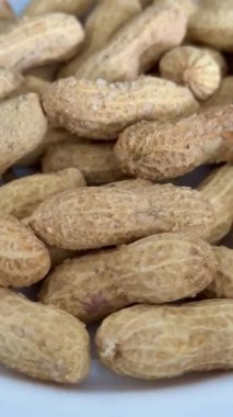 Kabuklarındaki tuzlu fıstıklardan beyaz bir tabakta. Sağlıklı ve lezzetli yemekler..