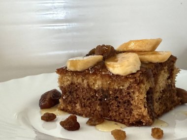 Muz dilimleri, kuru üzüm, hurma ve balla süslenmiş coğrafi bir çikolatalı turta..