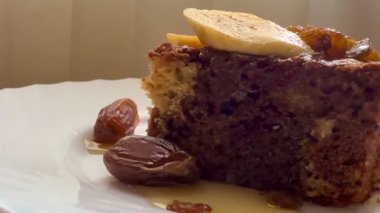 Muz dilimleri, kuru üzüm, hurma ve balla süslenmiş coğrafi bir çikolatalı turta. Lezzetli ev yapımı pişirmeler..