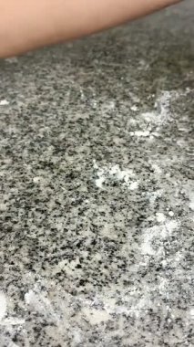 Kirli bir granit yüzeyi silen bir insan elinin yakın çekimi. Ev temizliği.