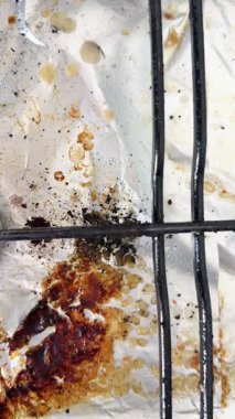 Pişirdikten sonra fırını temizleyen eski kirli bir gaz sobasının yakın çekimi. Ev temizliği.