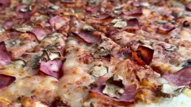 Peynirli, jambonlu ve mantarlı büyük klasik bir pizza. Lezzetli, besleyici ve hızlı bir yemek..