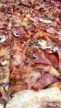 Peynirli, jambonlu ve mantarlı büyük klasik bir pizza. Lezzetli, besleyici ve hızlı bir yemek..