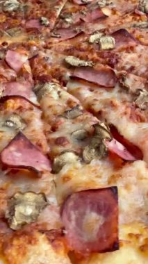 Peynirli, jambonlu ve mantarlı büyük klasik bir pizza. Lezzetli, besleyici ve hızlı bir yemek..