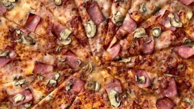 Peynirli, jambonlu ve mantarlı büyük klasik bir pizza. Lezzetli, besleyici ve hızlı bir yemek..