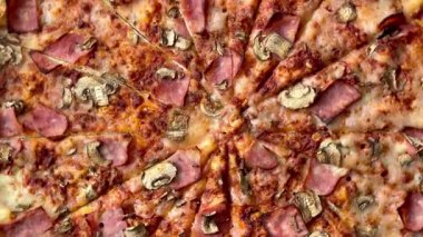 Peynirli, jambonlu ve mantarlı büyük klasik bir pizza. Lezzetli, besleyici ve hızlı bir yemek..