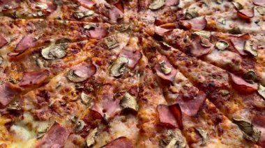 Peynirli, jambonlu ve mantarlı büyük klasik bir pizza. Lezzetli, besleyici ve hızlı bir yemek..