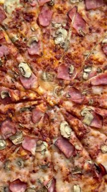 Peynirli, jambonlu ve mantarlı büyük klasik bir pizza. Lezzetli, besleyici ve hızlı bir yemek..