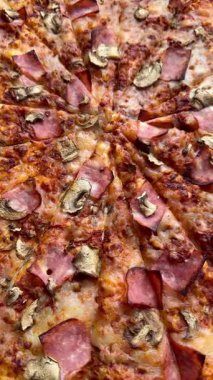 Peynirli, jambonlu ve mantarlı büyük klasik bir pizza. Lezzetli, besleyici ve hızlı bir yemek..