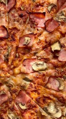 Peynirli, jambonlu ve mantarlı büyük klasik bir pizza. Lezzetli, besleyici ve hızlı bir yemek..