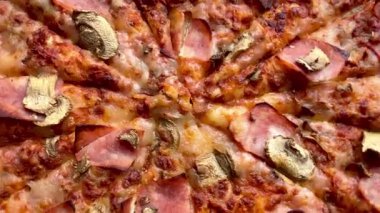 Peynirli, jambonlu ve mantarlı büyük klasik bir pizza. Lezzetli, besleyici ve hızlı bir yemek..