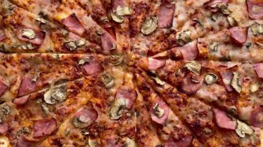 Peynirli, jambonlu ve mantarlı büyük klasik bir pizza. Lezzetli, besleyici ve hızlı bir yemek..