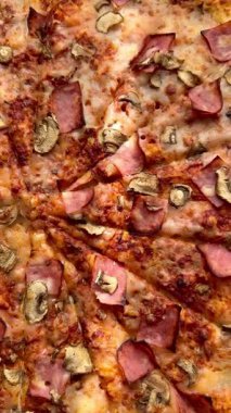 Peynirli, jambonlu ve mantarlı büyük klasik bir pizza. Lezzetli, besleyici ve hızlı bir yemek..