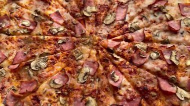 Peynirli, jambonlu ve mantarlı büyük klasik bir pizza. Lezzetli, besleyici ve hızlı bir yemek..