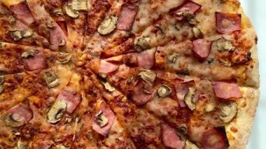 Peynirli, jambonlu ve mantarlı büyük klasik bir pizza. Lezzetli, besleyici ve hızlı bir yemek..