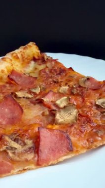 Peynirli, jambonlu ve mantarlı büyük klasik bir pizza. Lezzetli, besleyici ve hızlı bir yemek..