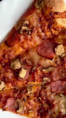 Peynirli, jambonlu ve mantarlı büyük klasik bir pizza. Lezzetli, besleyici ve hızlı bir yemek..