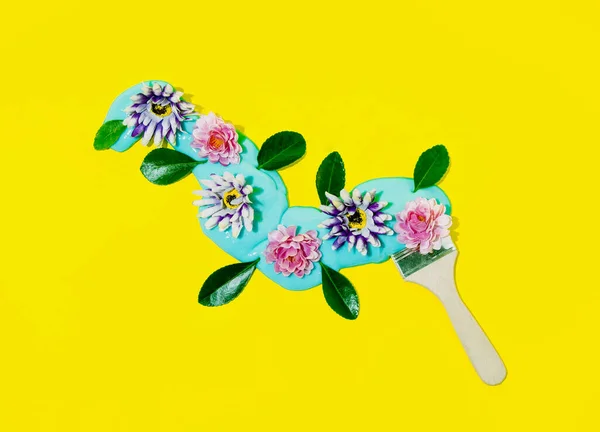 用蓝色黏液和五彩斑斓的花朵画画笔 黄色背景下的春季作曲 — 图库照片
