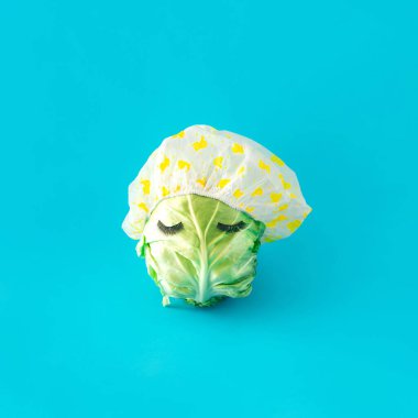 Mayo şapkalı lahana kafa. Kirpikli lahana. Pastel mavi arka planda.