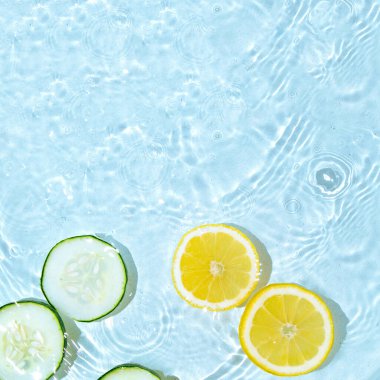 Suda en az limon ve salatalık konsepti. Mesaj için yer. Uzayı kopyala Yaz sahnesi. Meyve suyunu sıkıyorum..