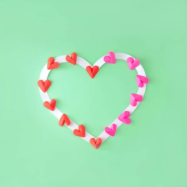 Frame from the heart. Place for text. Hearts in pink and red. Green background.