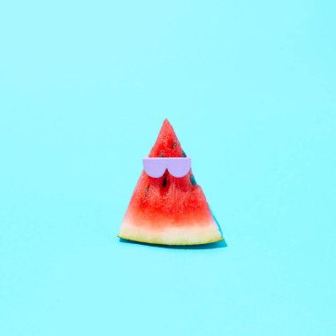 Güneş altında bir yaz plajında gözlüklü karpuz. Minimum bileşim. Mavi bir arkaplanda.