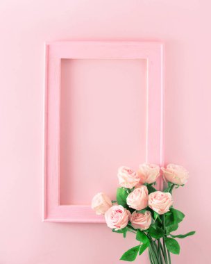 Yumuşak pembe bir buket çiçekli, yazı için yeri olan yumuşak pembe ahşap çerçeve. Pembe arka planda estetik.