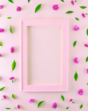 Tahta çerçeveli, çıplak pembe, küçük pembe çiçekler ve yeşil yapraklı yazılar için yer var. Pembe arka planda estetik.