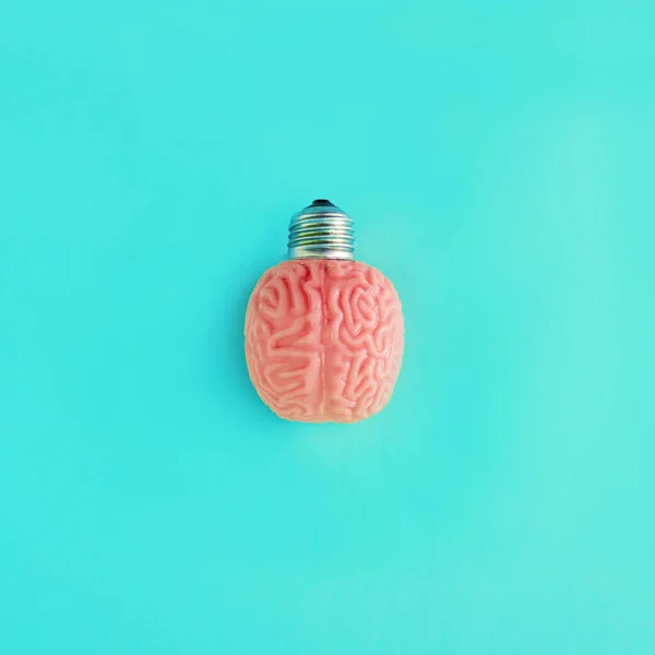 Light bulb brain. Minimal composition of an educational character on a blue background. Progress, Flowering, Work on yourself, Psychology.