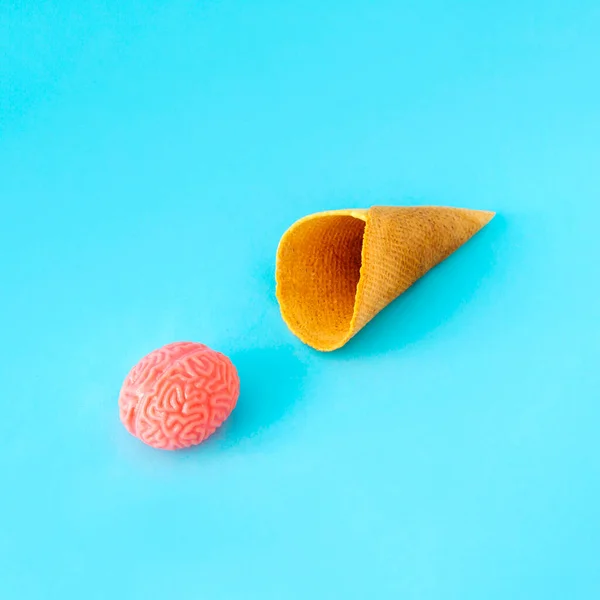冰淇淋锥形 蓝底上有一个脑球 假日的乐趣最小的概念 免版税图库图片