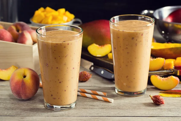 Zwei Pfirsich-Mango-Smoothies in Gläsern mit Zutaten — Stockfoto