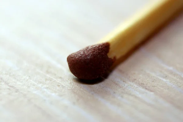 A close-up of the sulfur head of a match lies on the table. Macro — Stock Image Close Sulfur Head Match Lies Table Macro Stock Image