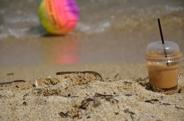 Кофе Frappe и пляжный мяч — стоковое фото