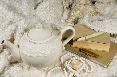 Çaydanlık, yün kumaş ve kitaplar