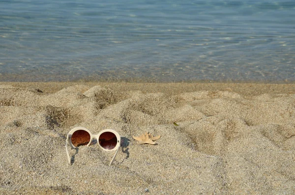 Sun glasses with sea star on a beach — Stock Photo, Image