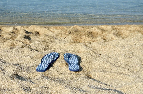 Blue flip flops on a beach — Stock Photo, Image