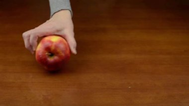 Elma ahşap bir masa yüzeyinde yuvarlanıyor