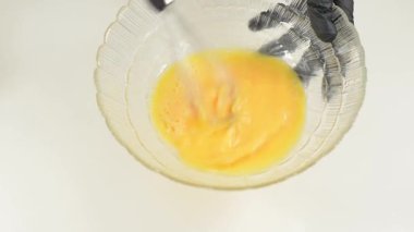 Metal telle çırpılmış cam kasede yumurta çırpma.