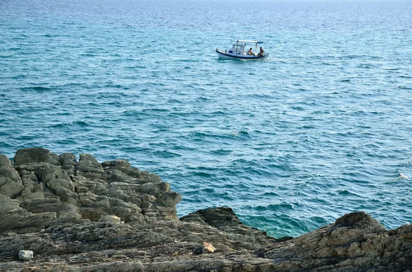 Морские скалы и рыбацкая лодка — стоковое фото
