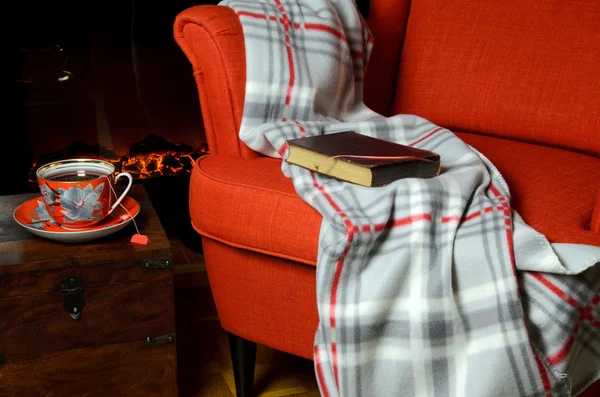 Одеяло, книга и чай у камина — стоковое фото