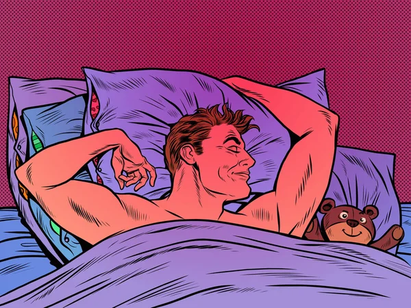 Lindo hombre con un oso de juguete durmiendo dulcemente en la cama — Vector de stock