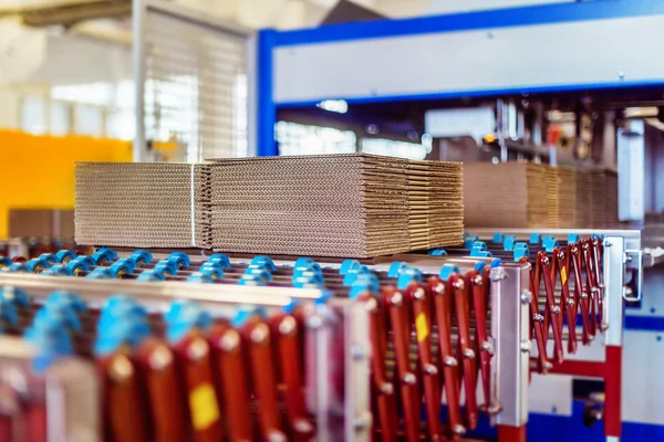 Closeup image of cardboard boxes on conveyor belt in distribution warehouse